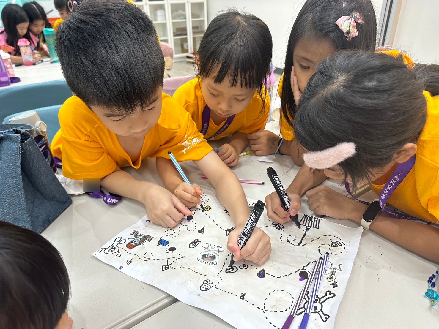 Children working together on a shared drawing.