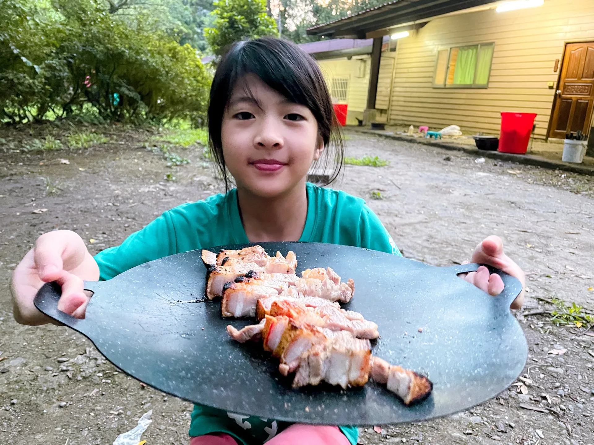 孩子雙手端著放有切塊食物的圓盤